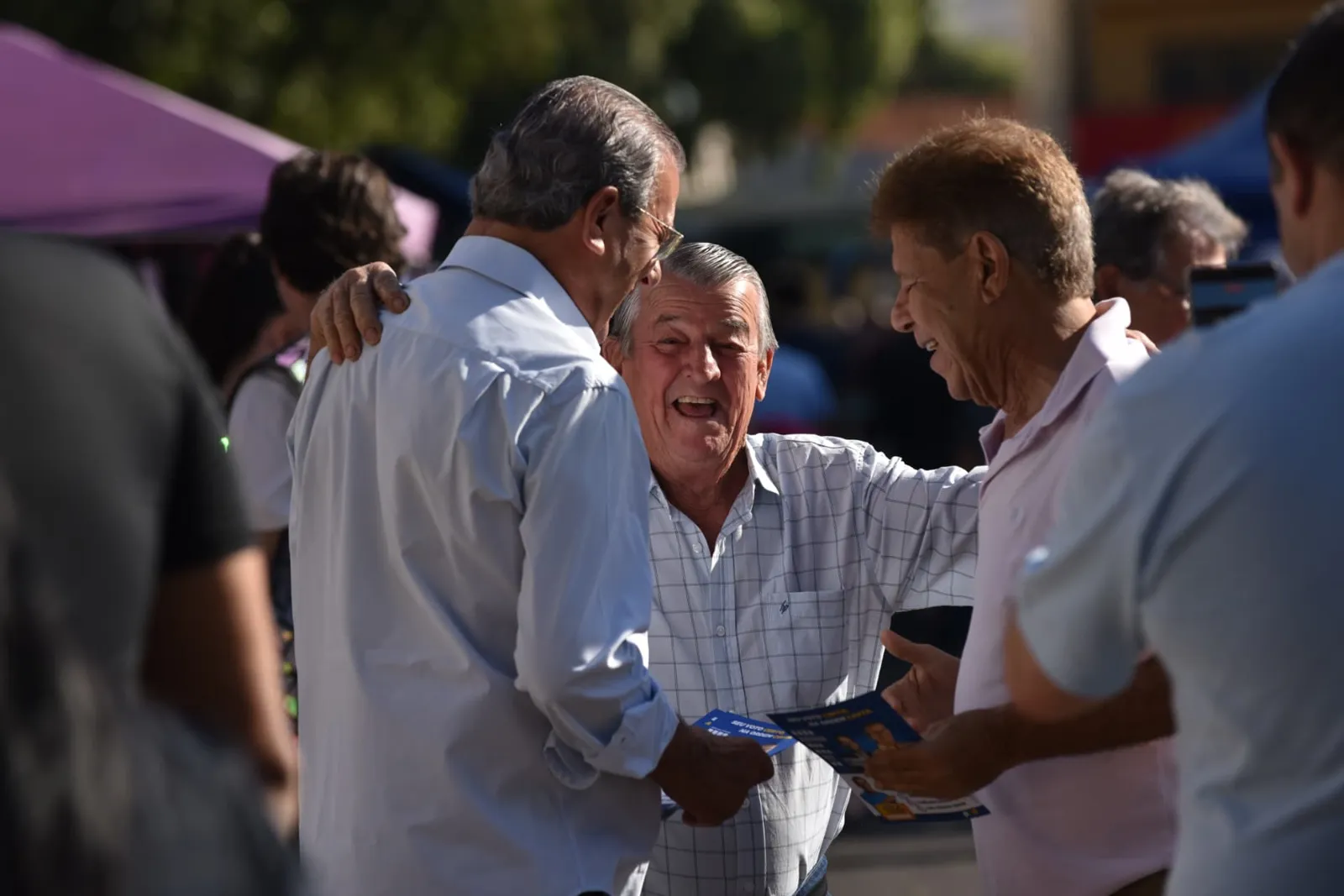 Dilador Borges rindo com amigos em evento de rua