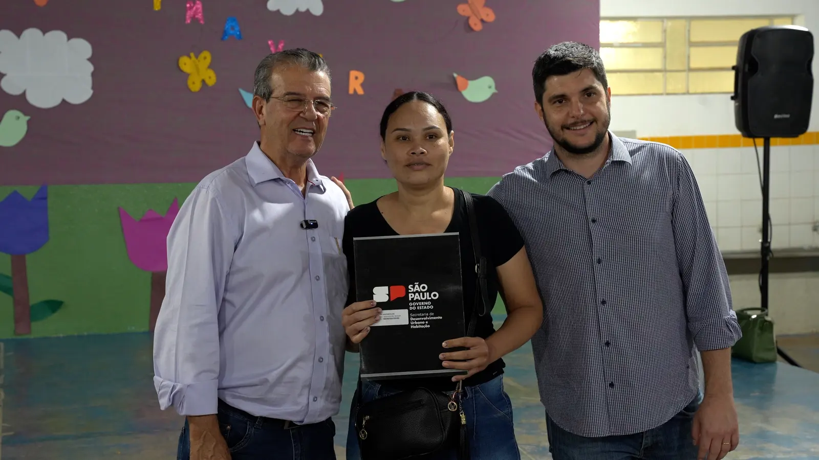 Família recebendo escritura da casa própria